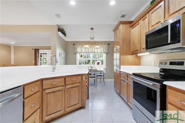 kitchen featuring light countertops, visible vents, appliances with stainless steel finishes, brown cabinetry, and a sink