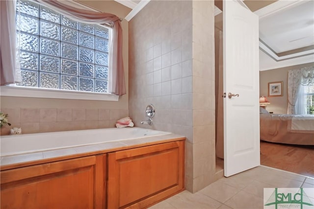 ensuite bathroom with ensuite bathroom, tile patterned flooring, a garden tub, and tile walls