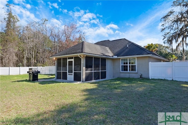 back of property with a sunroom, a fenced backyard, a shingled roof, and a yard