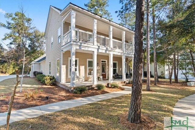230 Blackjack Oak Dr W, Richmond Hill, GA 31324 - view of front of property with a balcony, covered porch, and a front yard
