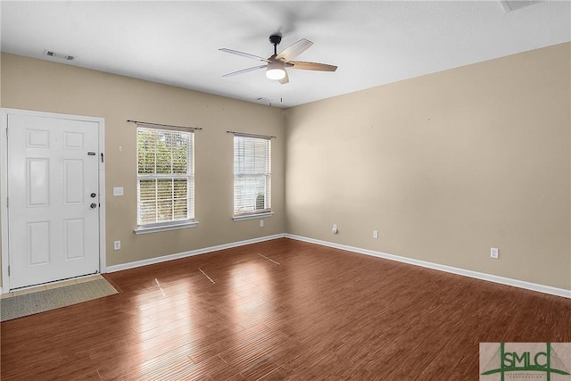 interior space with ceiling fan, dark wood finished floors, visible vents, and baseboards