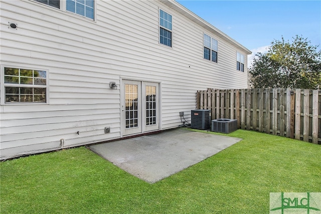 rear view of house featuring central air condition unit, a patio area, fence, and a yard