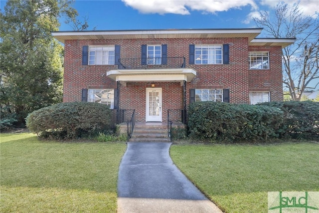 view of front facade with brick siding and a front yard