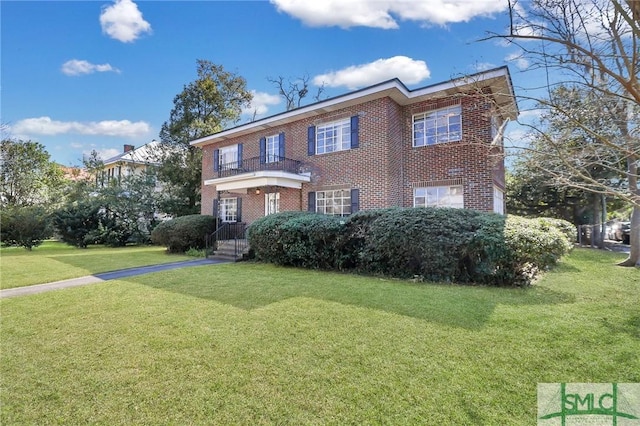 view of front of home with a front yard and brick siding