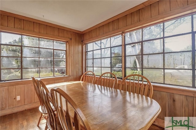 dining room with wood walls and wood finished floors