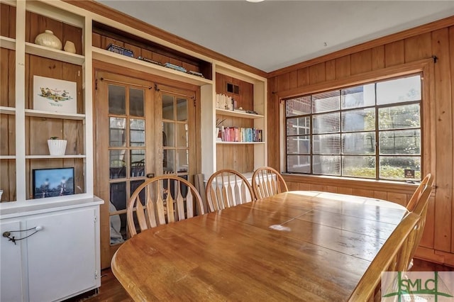 dining room with built in shelves and wooden walls