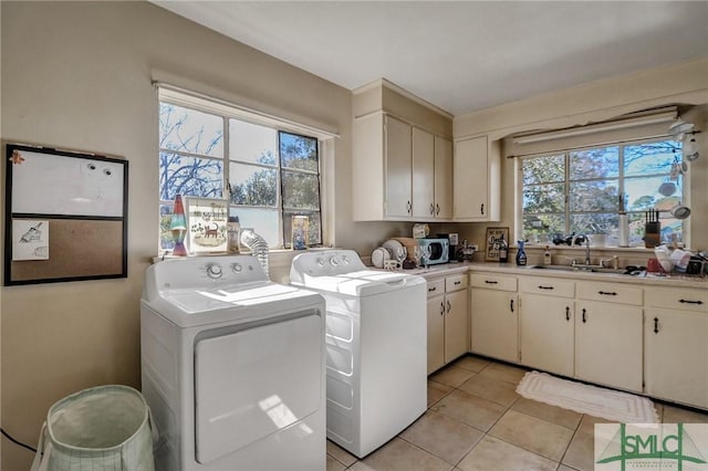 laundry room featuring a sink, cabinet space, washer and dryer, and light tile patterned flooring