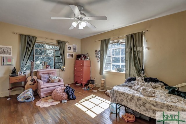 bedroom featuring a ceiling fan, baseboards, and wood finished floors