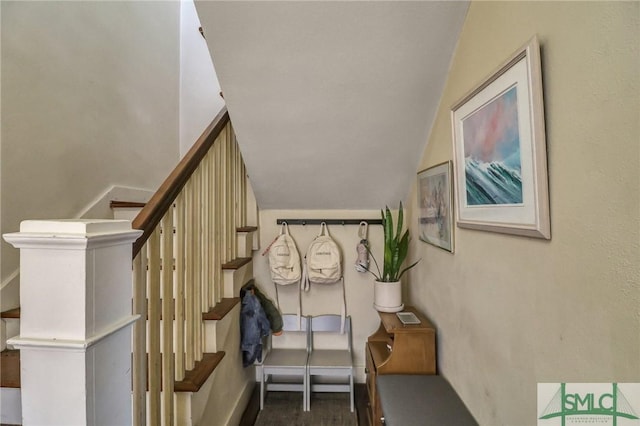 stairway with lofted ceiling and baseboards