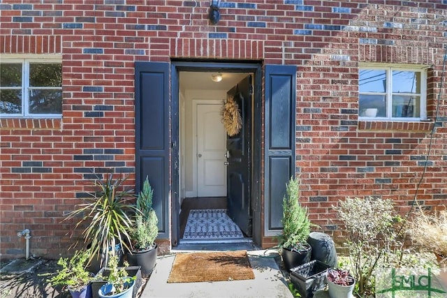 entrance to property featuring brick siding