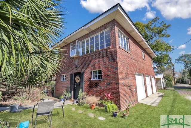 view of front of house featuring a garage, a front yard, and brick siding