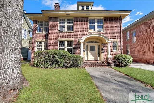 view of front of home featuring brick siding, a front lawn, a chimney, and cooling unit