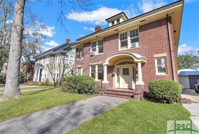 view of front of property featuring a garage, brick siding, a chimney, and a front yard