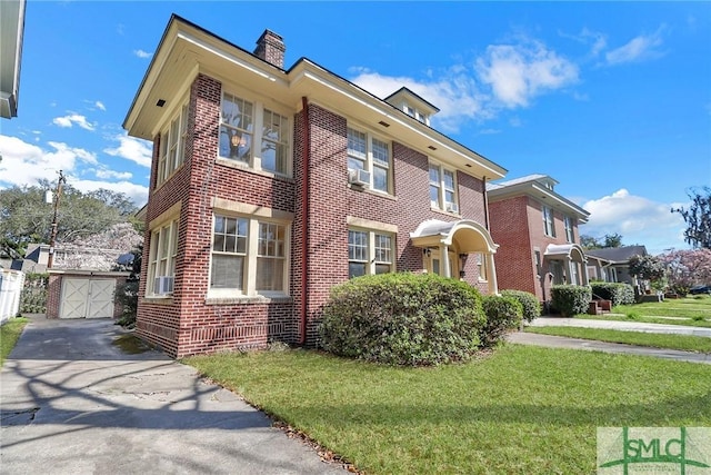 view of front of home with brick siding, a chimney, concrete driveway, and a front yard
