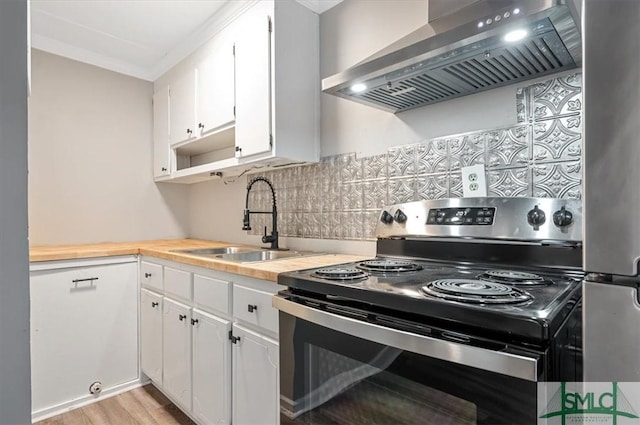 kitchen with white cabinets, electric stove, wall chimney exhaust hood, backsplash, and a sink