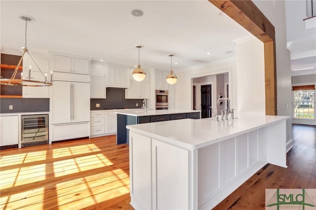106 Commodore Dr, Savannah, GA 31410 - kitchen with a center island with sink, a peninsula, paneled built in fridge, wine cooler, and light wood-style floors