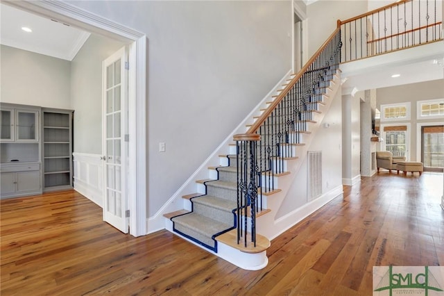 106 Commodore Dr, Savannah, GA 31410 - staircase featuring visible vents, ornamental molding, wood-type flooring, a high ceiling, and baseboards