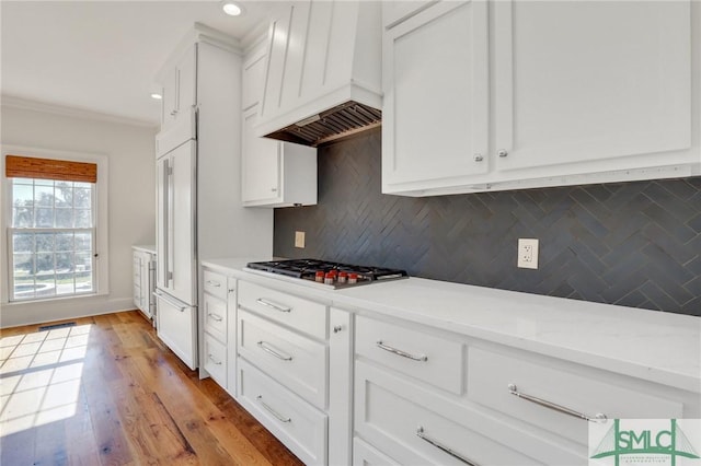 106 Commodore Dr, Savannah, GA 31410 - kitchen with premium range hood, tasteful backsplash, white cabinetry, paneled built in fridge, and light countertops