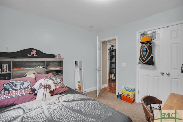 bedroom with a closet, carpet flooring, and baseboards