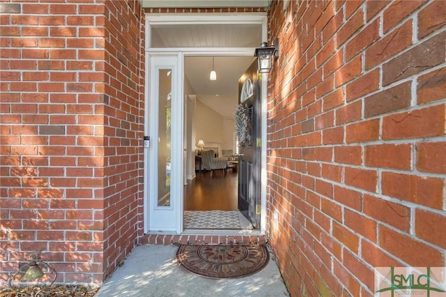 doorway to property with brick siding