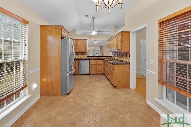 kitchen with tasteful backsplash, dark countertops, lofted ceiling, appliances with stainless steel finishes, and a sink