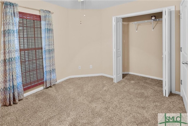 unfurnished bedroom featuring carpet flooring and baseboards