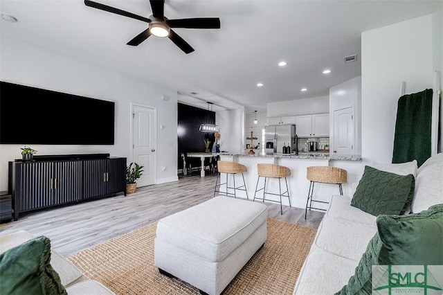 living area with light wood finished floors, recessed lighting, visible vents, ceiling fan, and baseboards