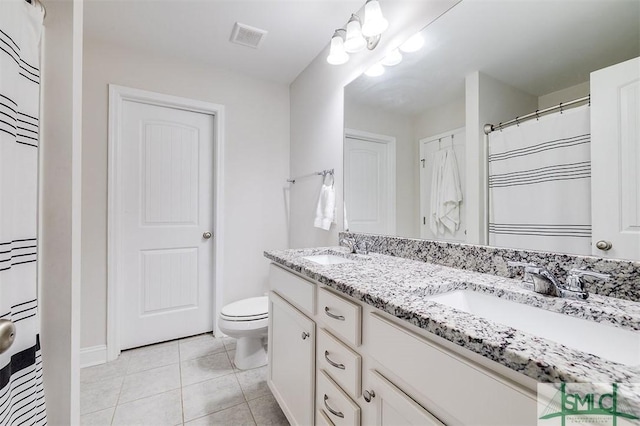 bathroom featuring tile patterned flooring, toilet, a sink, visible vents, and double vanity