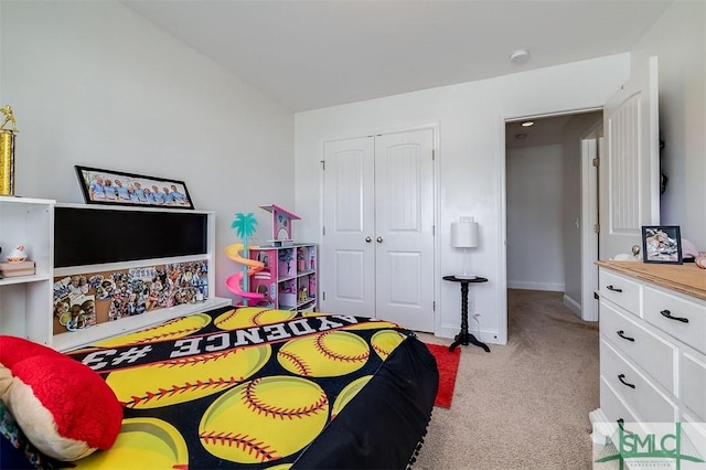 bedroom with lofted ceiling, a closet, light carpet, and baseboards