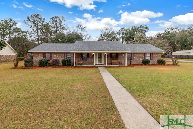 single story home featuring covered porch, brick siding, and a front lawn