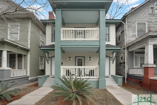 view of property featuring a porch and a balcony