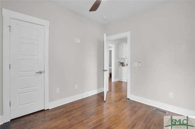 unfurnished bedroom featuring dark wood finished floors and baseboards