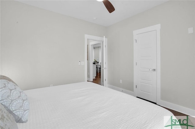 bedroom with wood finished floors, baseboards, and a ceiling fan