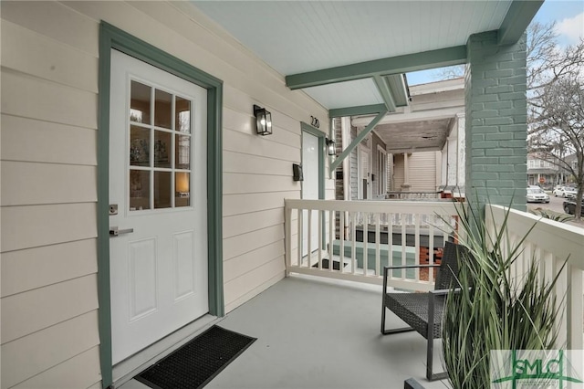 view of exterior entry featuring covered porch