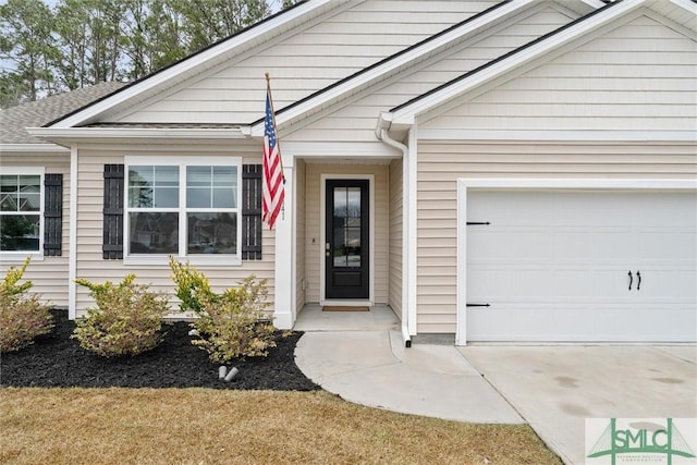 doorway to property featuring a garage, concrete driveway, and roof with shingles