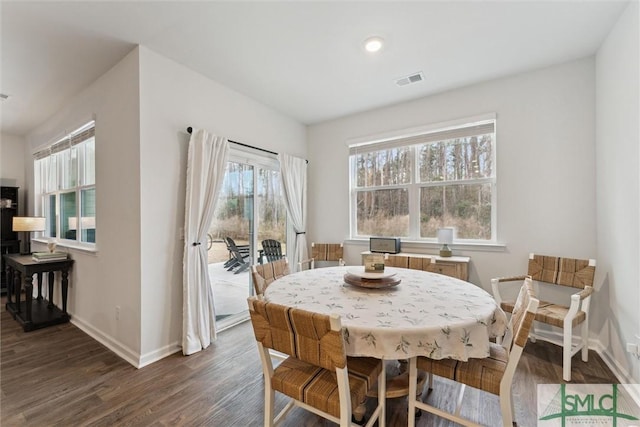 dining room with dark wood-style floors, visible vents, and baseboards