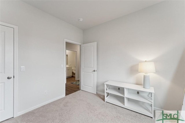 bedroom featuring light carpet and baseboards