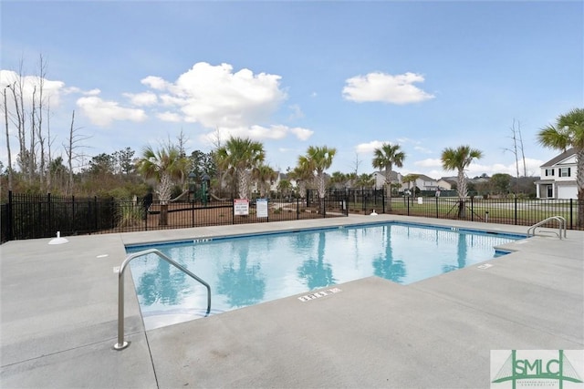 pool with a patio area and fence