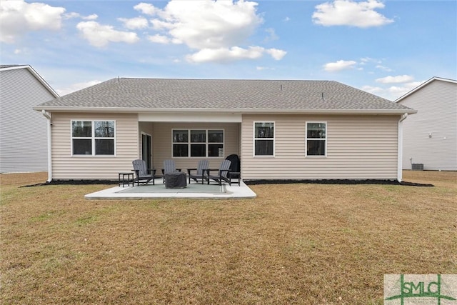 rear view of property featuring a yard, roof with shingles, and a patio