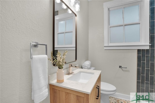 bathroom with a shower, baseboards, vanity, and toilet