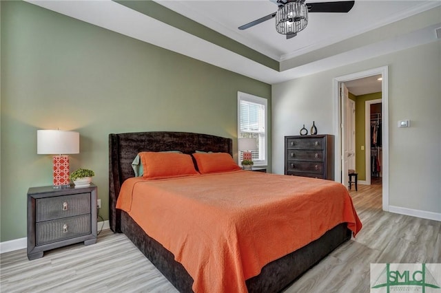 bedroom featuring light wood finished floors, a ceiling fan, and baseboards