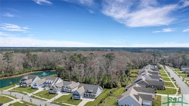 birds eye view of property with a water view, a residential view, and a view of trees