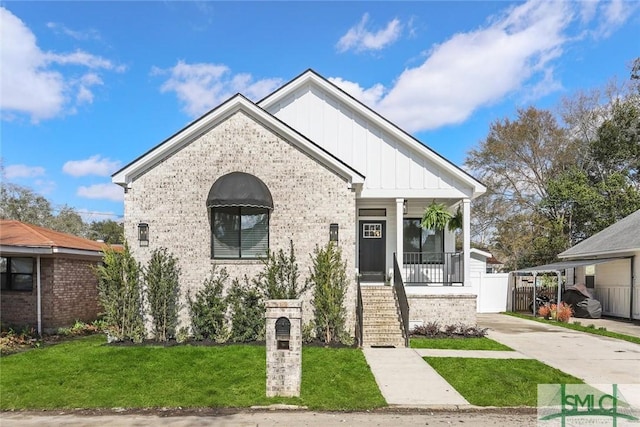 1212 Seiler Ave, Savannah, GA 31404 - view of front of home with board and batten siding, brick siding, covered porch, stairway, and concrete driveway
