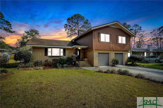 split level home with brick siding, driveway, an attached garage, and a lawn