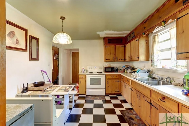 kitchen featuring dark floors, decorative light fixtures, white range with electric cooktop, light countertops, and a sink