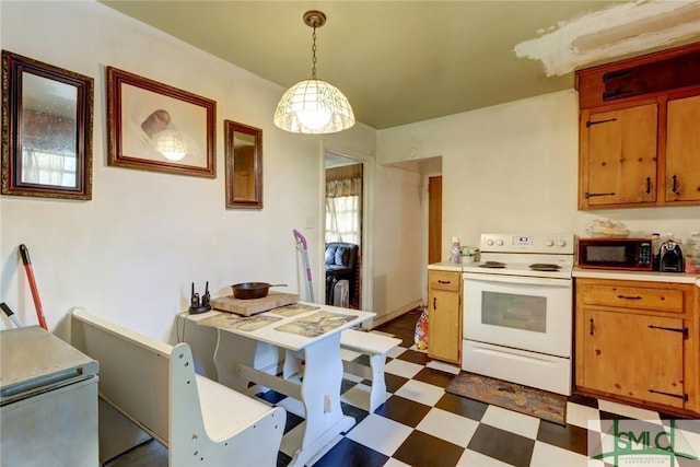 kitchen featuring dark floors, electric range, hanging light fixtures, light countertops, and brown cabinetry