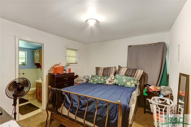 bedroom featuring light carpet and connected bathroom