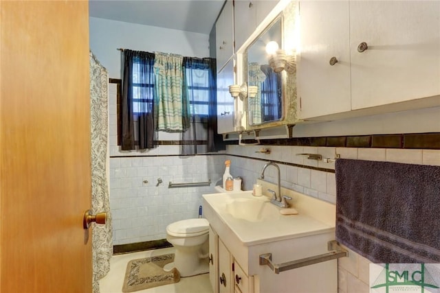 full bath with toilet, tile walls, and vanity