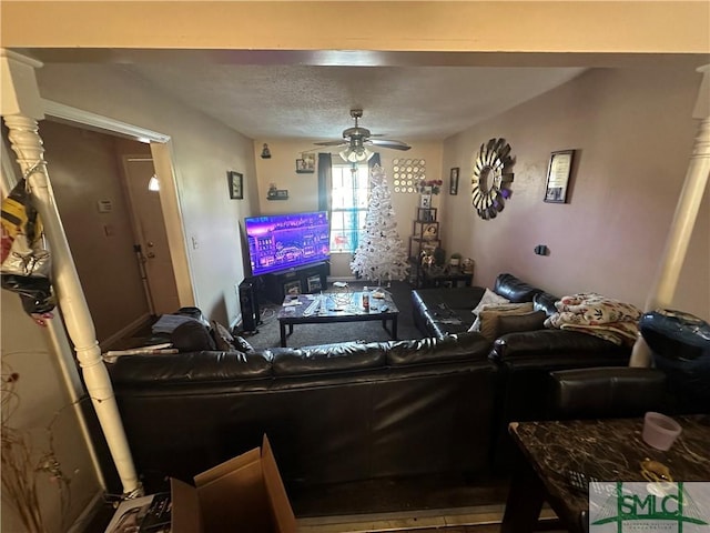 living room featuring a ceiling fan and a textured ceiling