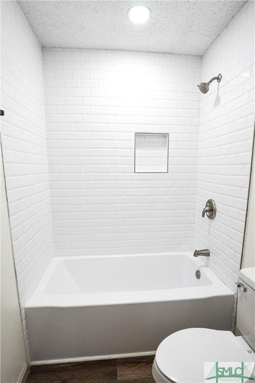 bathroom featuring toilet, shower / tub combination, a textured ceiling, and wood finished floors